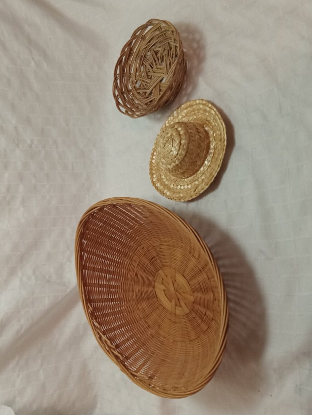 Two decorative vintage containers and a hat made of straw and rattan